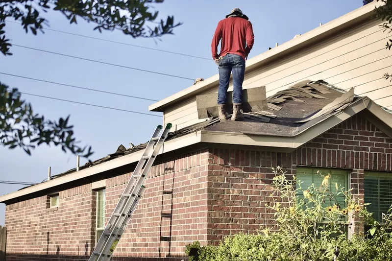 Professional roofer working on a residential roof in Ray Center